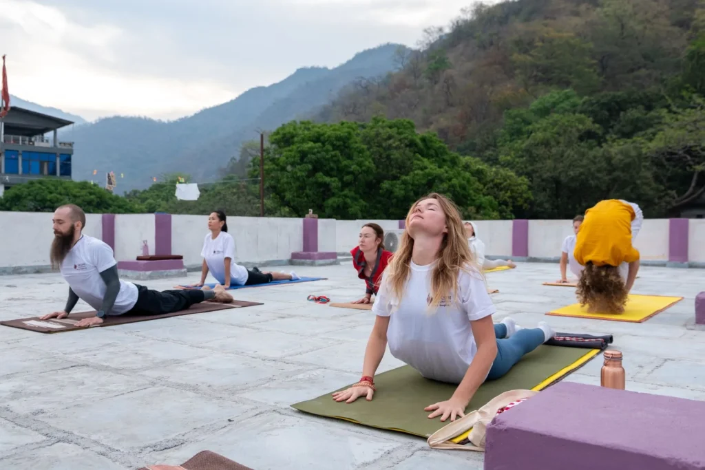 A small group practicing yoga together on an outdoor mountain terrace at a wellness retreat